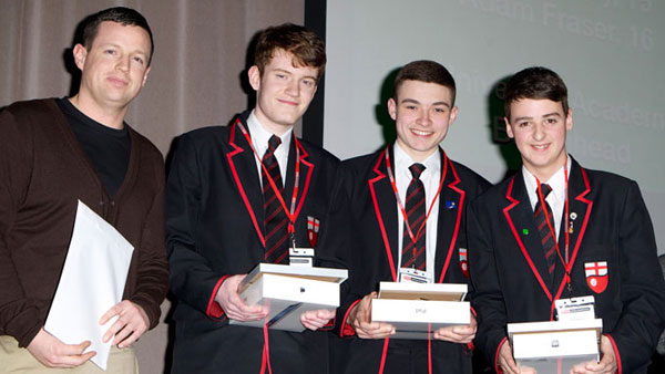 A group of young men holding awards with their teacher